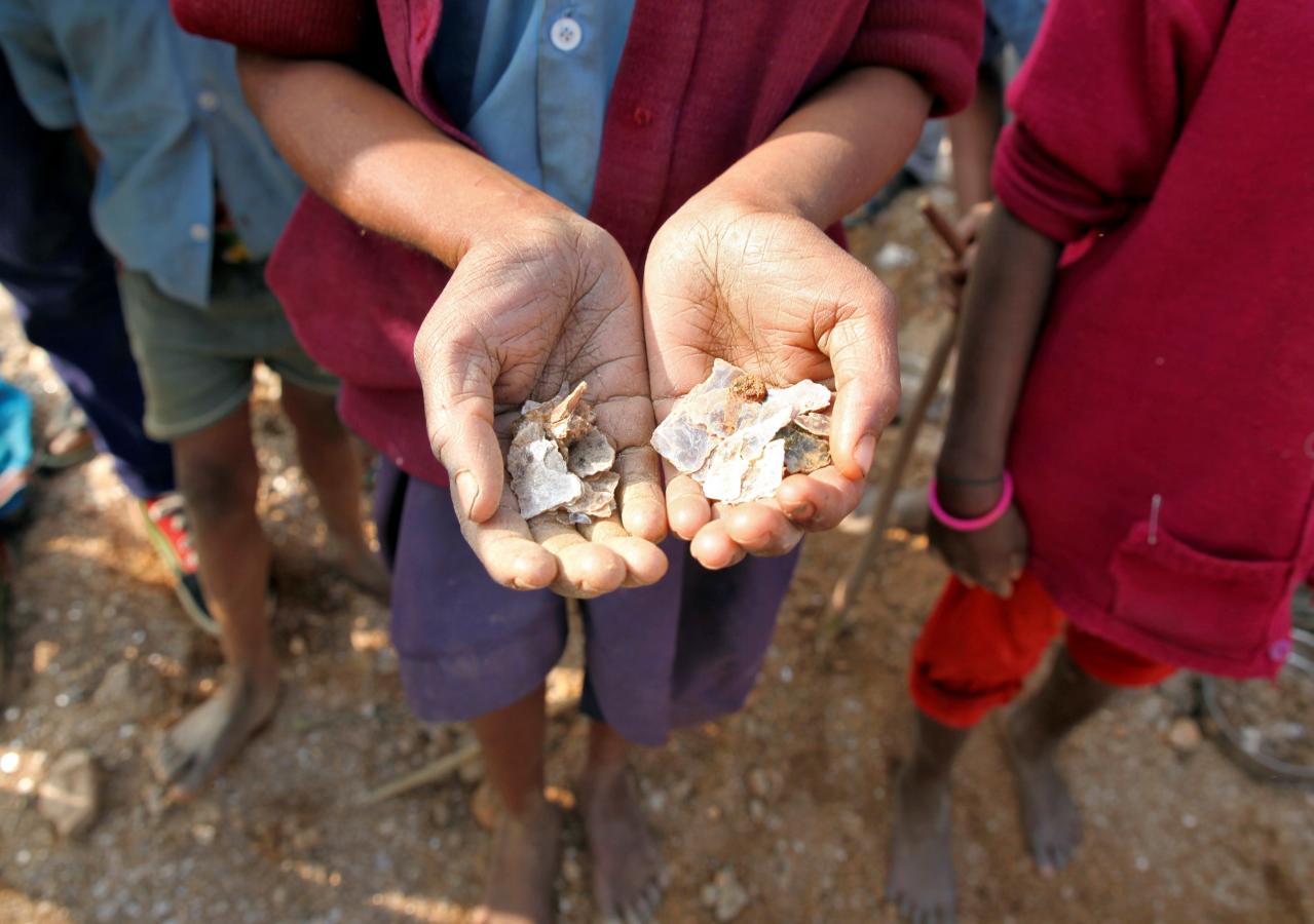 Girl holding mica flakes she collected in Indian mine - Reuters